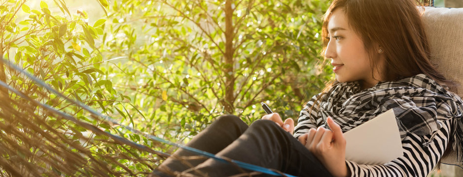 Beautiful young teenage woman write note onwhite notebook, dimension image for banner