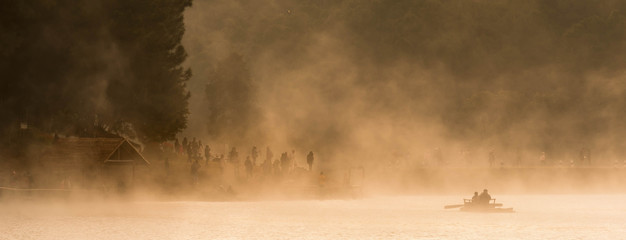 People get on bamboo raft, morning adventure in winter with fog float on surface water