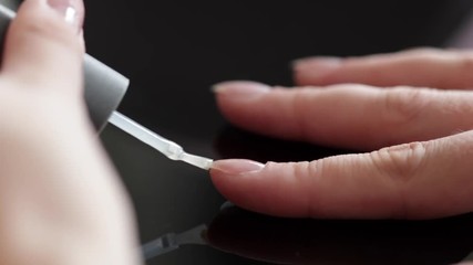 Applying nail polish on fingers