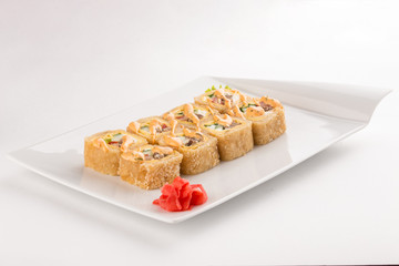 tempura sushi maki roll with shrimp, avocado and mayo on top isolated on white background