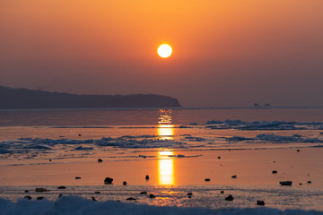 Seascape ice beach and the red sunset.