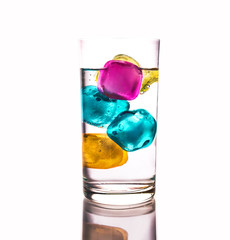 Glass of clear glass with mineral water and ice. Colorful ice.