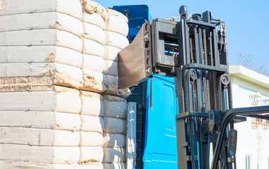 Forklift loading the bales of coton in a truck (TIR) - Cotton bales, ready for delivery to cotton buyers.