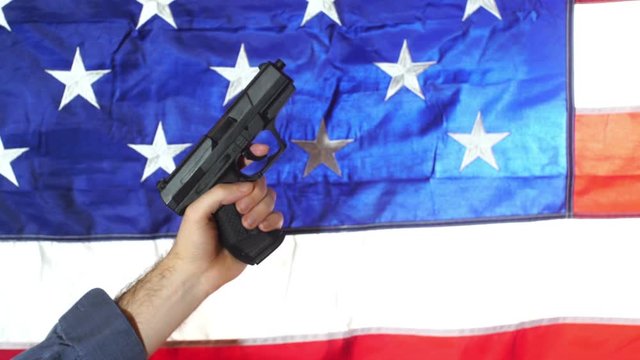 holding a pistol up with an american flag