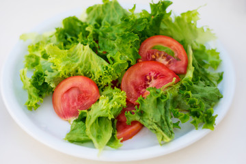 Delicious salad with sliced tomatoes on the white plate