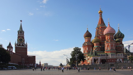 Obraz premium Russia, Moscow, Vasilievsky descent, view of the Spasskaya tower of the Kremlin and St. Basil's Cathedral on a Sunny summer day against the blue sky, Red Square the main city landmark