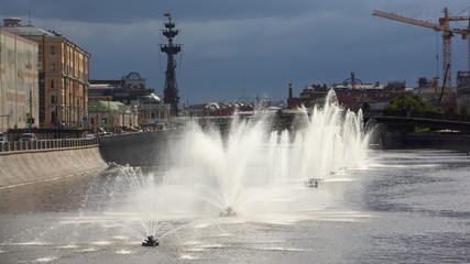 Russia, Moscow, Fountains on Vodootvodny canal, wide view from Bolotnaya square on a summer day against dark blue stormy sky