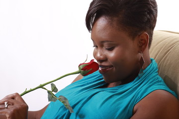 Close-Up of black woman smelling rose and smiling romantic