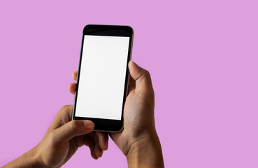 Hand holding white mobile phone with blank white screen in Plum background.