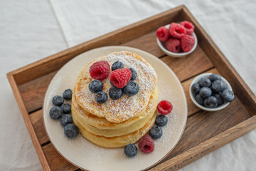 home made sweet vanilla pancakes with berries on a table