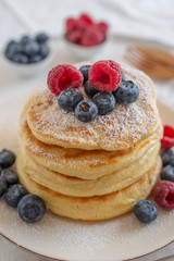 home made sweet vanilla pancakes with berries on a table