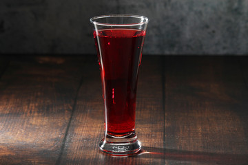Red juicy drink in a high beer glass