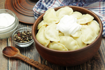 A ceramic bowl with freshly cooked Russian vareniki with mashed potato