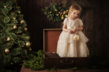  little girl in dress with christmas tree in retro style