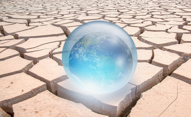 Global warming concept - Crystall ball on the sand dune with Glass Globe (Planet Earth) "Elements of this image furnished by NASA"
