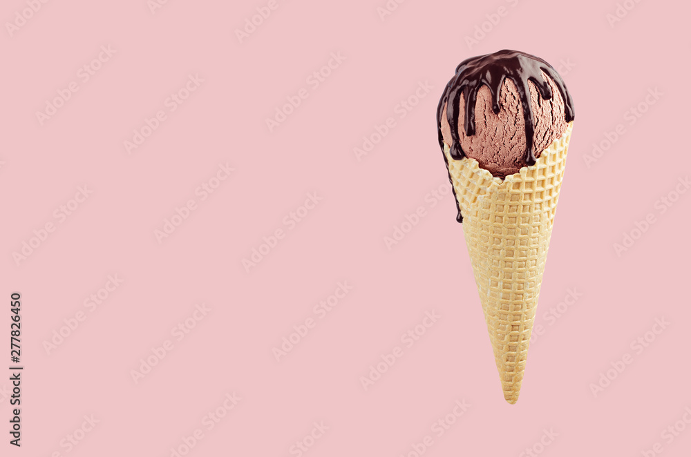 Wall mural Brown ice cream in crisp waffle cone with chocolate sauce on pastel pink background, mock up for design.