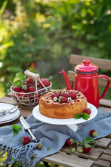 cake with fresh strawberry on wooden table in a garden