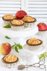 Apfel-Muffins auf Tortenplatte und frische Äpfel