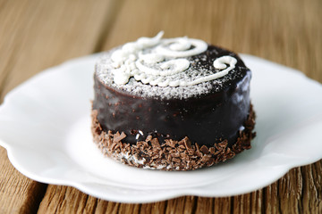 Obraz na płótnie Canvas chocolate pastry sweet cake on a white plate. Homemade bakery, festive dessert