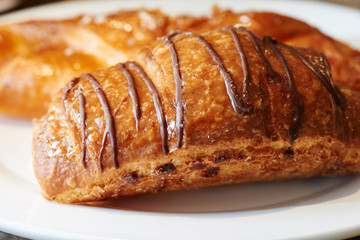 Appetizing strudel with apples and berries on a white plate. Homemade pastry pastry, bun with topping