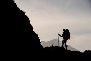 Silhouette of female hiker walking on mountain
