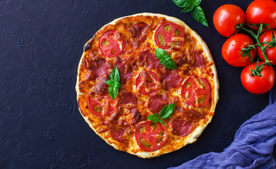 Homemade spicy pizza with sausage and tomato.