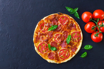 Homemade spicy pizza with sausage and tomato.