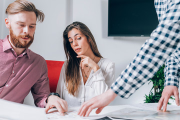 Real-Estate Agent Showing a Build Project to a Young Couple