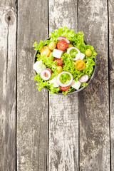 Green salad on wooden table. Food background