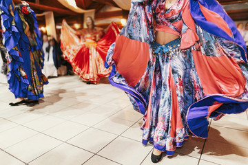 Gypsy dance festival, Woman performing romany dance and folk songs in national clothing. Beautiful roma gypsy girls dancing in traditional floral dress at wedding reception in restaurant