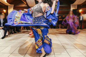 Gypsy dance festival, Woman performing romany dance and folk songs in national clothing. Beautiful roma gypsy girls dancing in traditional floral dress at wedding reception in restaurant