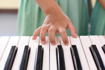 Schoolgirl hands are playing the piano.