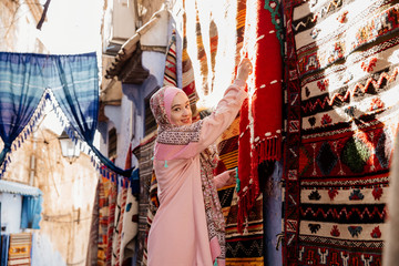 Obraz premium Tourist on a street with carpets - Chefchaouen, Morocco