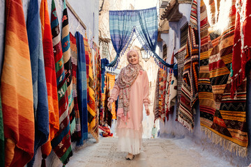 Fototapeta na wymiar Tourist on a street with carpets - Chefchaouen, Morocco