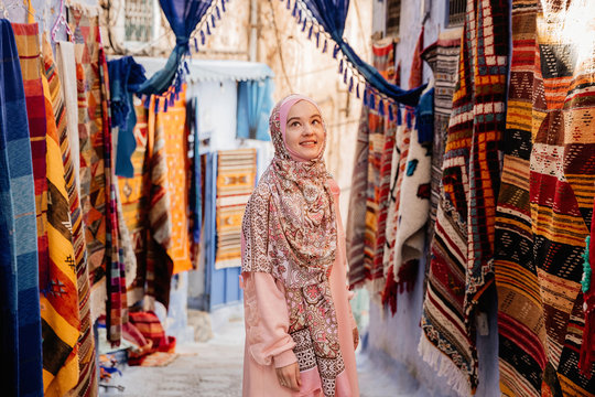 Tourist on a street with carpets - Chefchaouen, Morocco