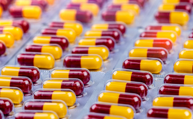 Red-yellow capsule in blister pack. Antibiotic capsule pills. Antimicrobial drug resistance. Penicillin drug for treatment infection. Amoxicillin medicine for kill bacteria. Pharmaceutical industry.