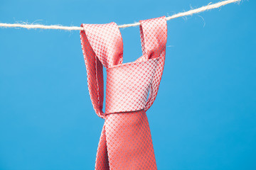 Nudo de corbata clásica, colgada de una cuerda y sujeta por pinzas de madera de colgar la ropa....