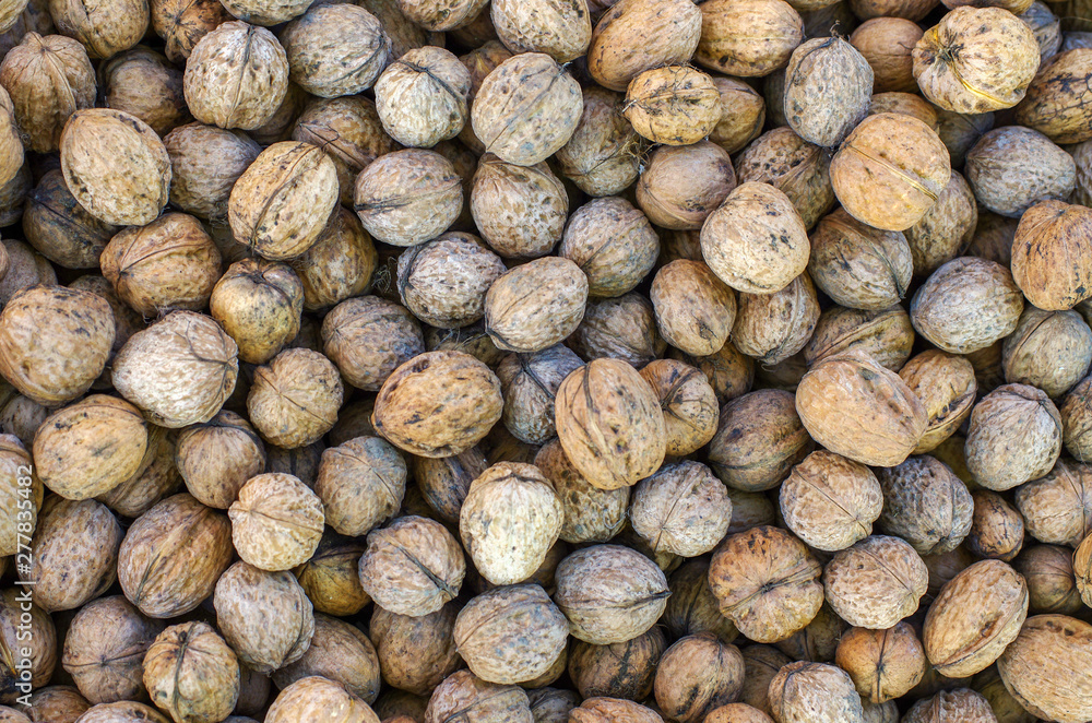 Wall mural Natural fresh walnuts background texture.