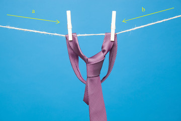 Corbata y el nudo de la corbata, colgadas de una cuerda y sujetos por unas pinzas de madera de las...