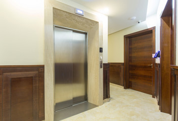 Hotel corridor with shiny metal elevator