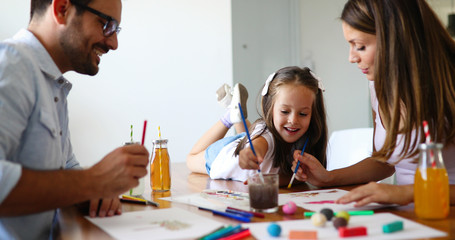 Fototapeta premium Mom and dad drawing with their daughter