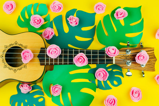 top view of a guitar and rose flowers pattern on vibrant   yellow background