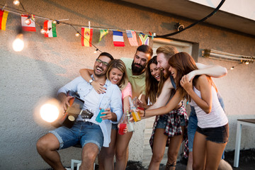 Group of happy friends having party on rooftop