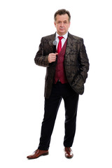Full length body of happy and successful senior man 60-65 years old. Businessman senior stand in beautiful suit with red tie and white shirt. Grinning Man hold microphone. Isolated on white background