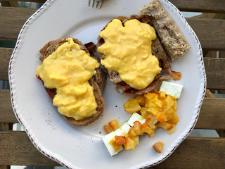 Homemade Creamy Scrambled Eggs in Breakfast Plate with Toast Bread, Cheese Cherry and Orange Jam / Marmalade.
