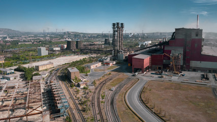 Fototapeta na wymiar Concept of environmental pollution, drone view of smokestack pipe steel plant, aerial industrial panoramic landscape with blue sky and autumn vegetation, air emissions from manufacturing sector,Russia