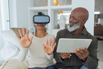 Couple using digital devices while sitting inside a room