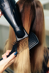 Fototapeta premium stylist's work with the hair of a girl in a beauty salon