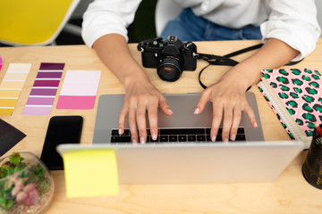 Female graphic designer using laptop at desk in office
