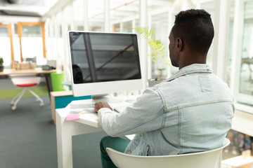 Fototapeta premium Male graphic designer working on computer at desk